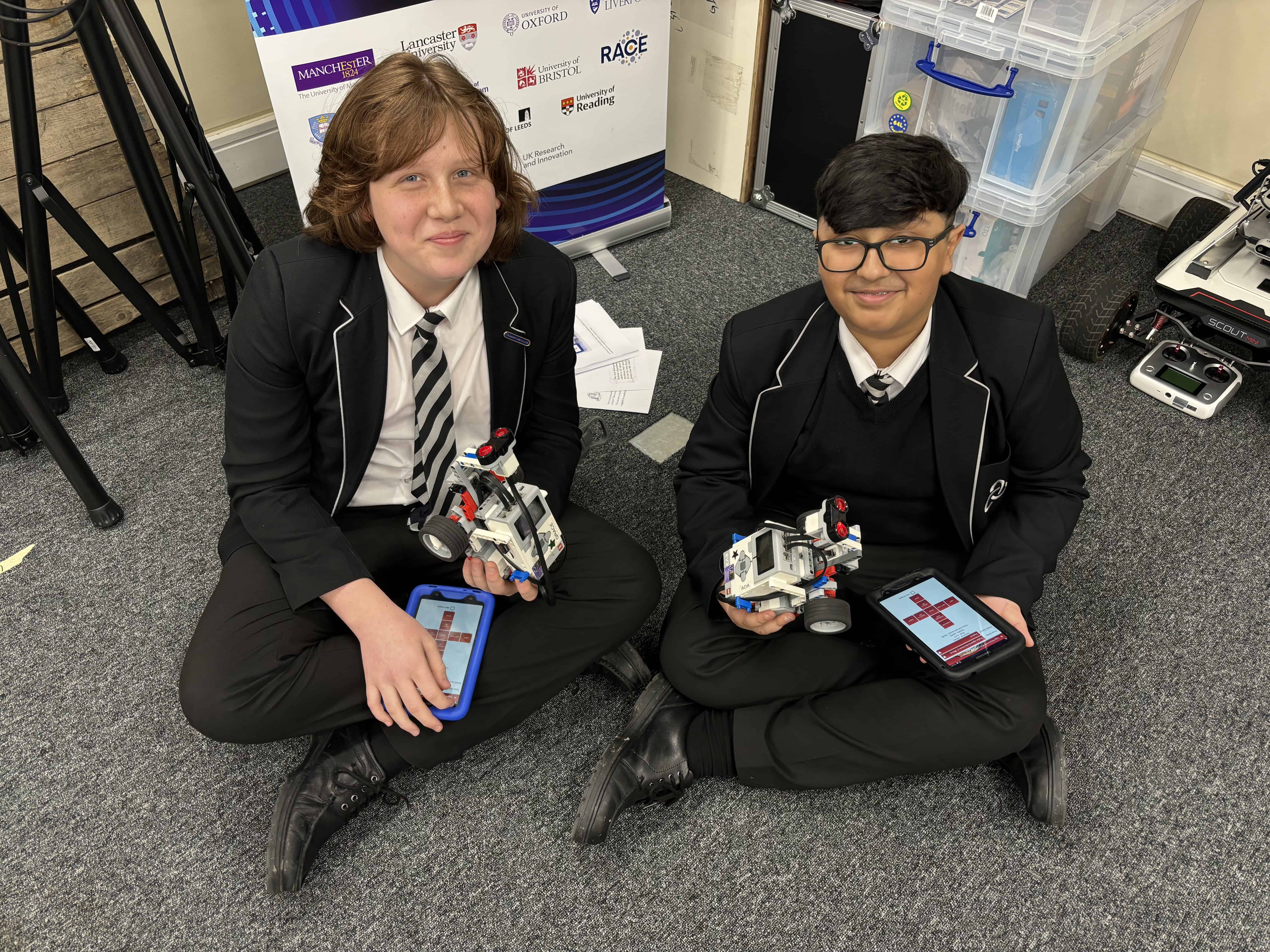 Two students from Laurus Ryecroft hold their Lego Rovers at the University of Manchester Computer Science department.