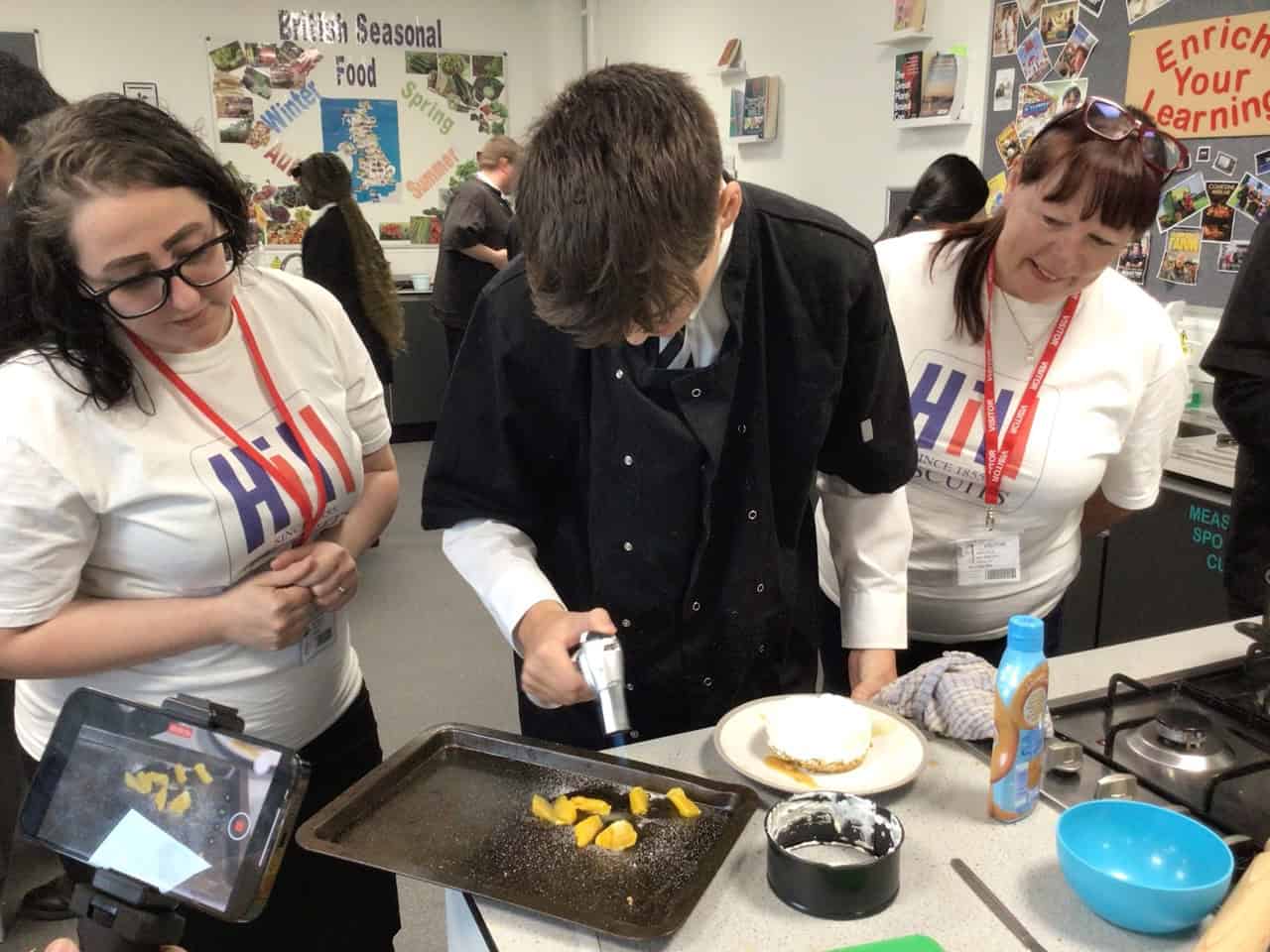 A Laurus Ryecroft student uses a blowtorch while making a cheesecake for National Biscuit Day.