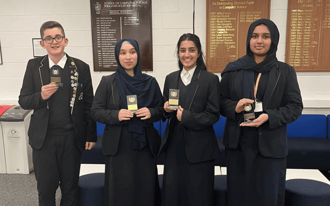 Laurus Ryecroft student Oliver and 3 students from Eden Girls' Leadership Academy stand holding medals achieved in the North West STEM Challenge January 2024 at the University of Manchester.