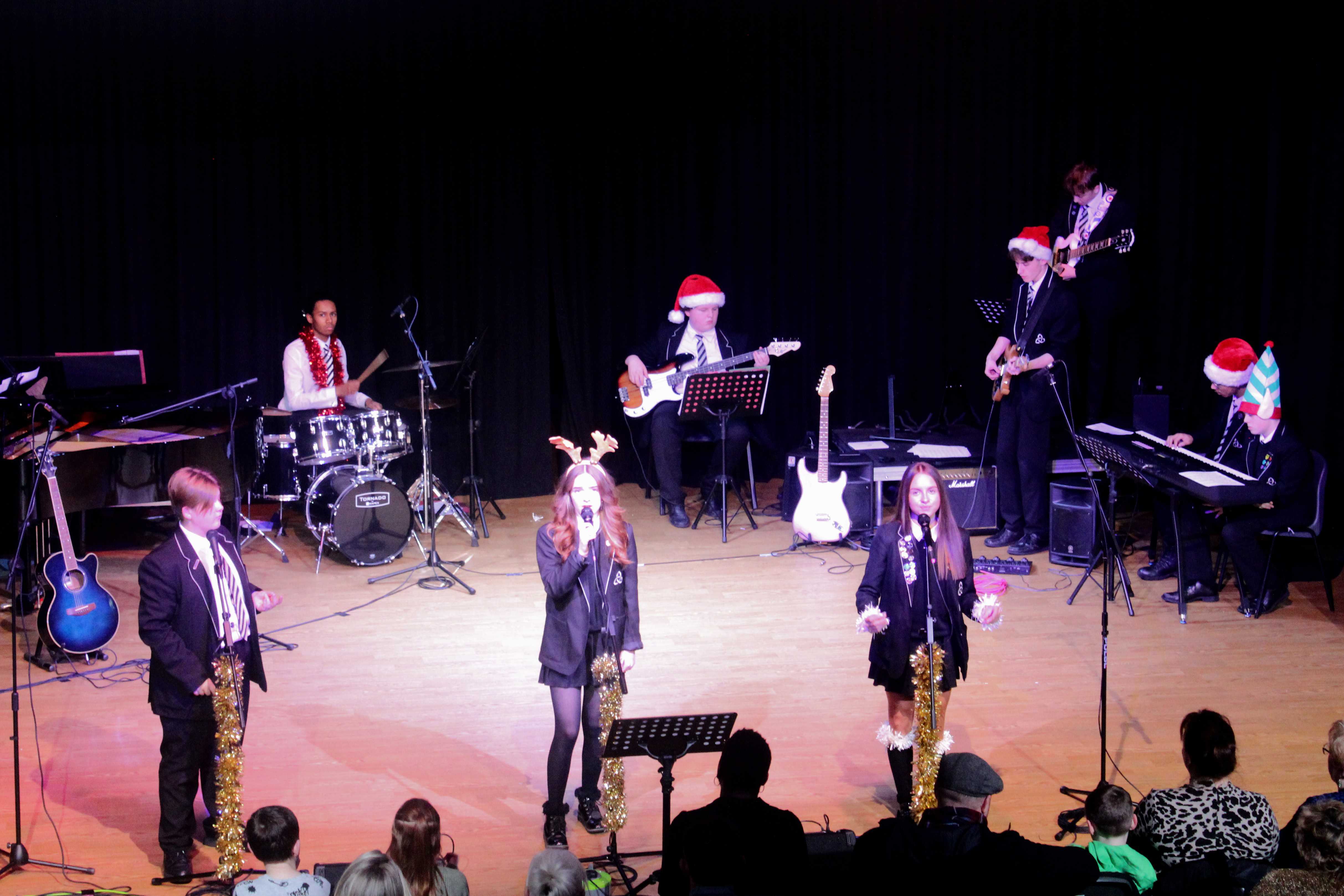 Students perform in a band wearing Christmas hats at Laurus Ryecroft Winter Wonderland 2023