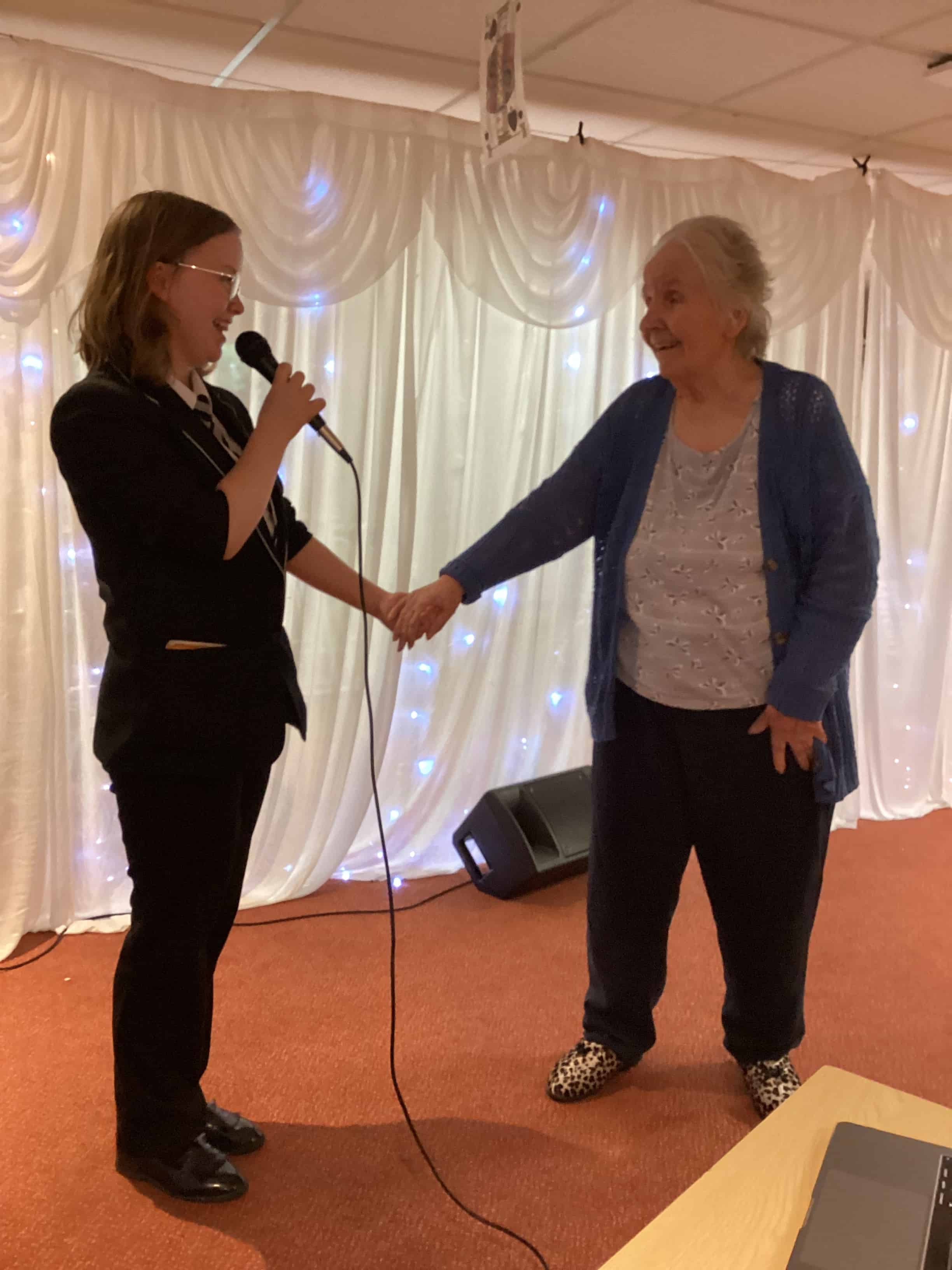 A Laurus Ryecroft student sings with a resident at a care home as part of their active citizenship mission
