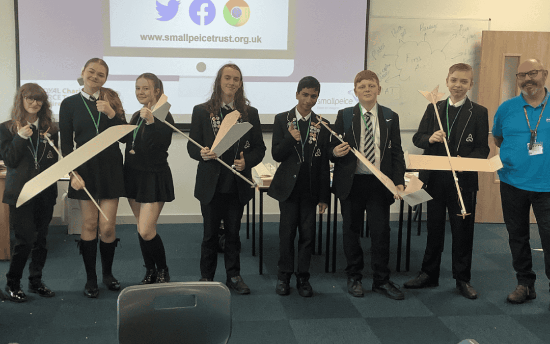 Students from Laurus Ryecroft stand in a classroom holding the airplanes they crafted as part of the Road to RIAT: Blast Off! STEM challenge day with the Smallpeice Trust.