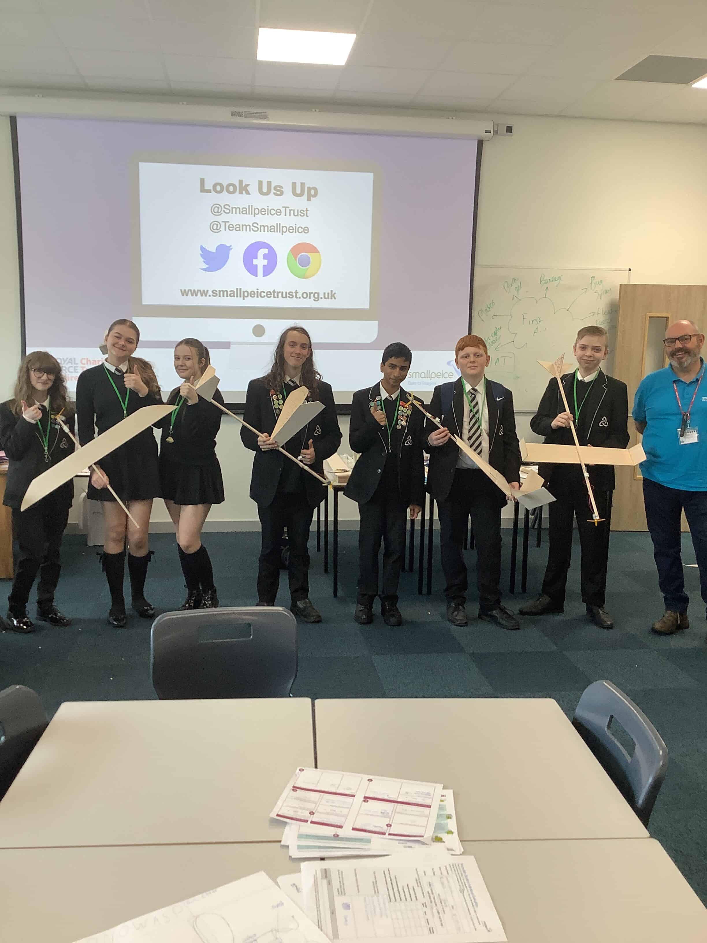 Students from Laurus Ryecroft stand in a classroom holding the airplanes they crafted as part of the Road to RIAT: Blast Off! STEM challenge day with the Smallpeice Trust.